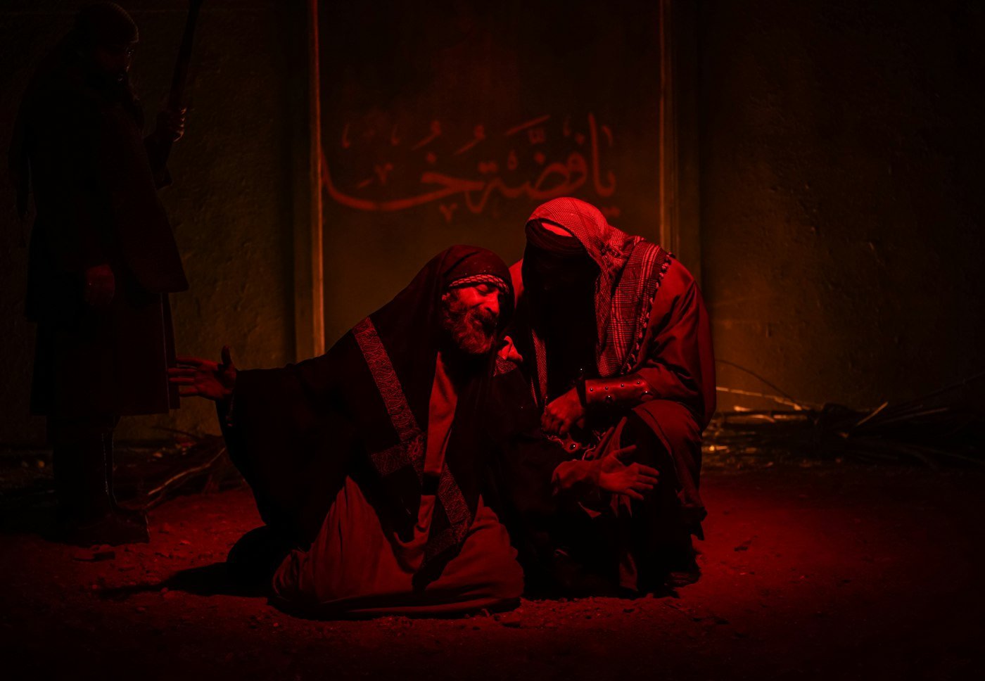 Deux interprètes au sol dans une lumière rouge