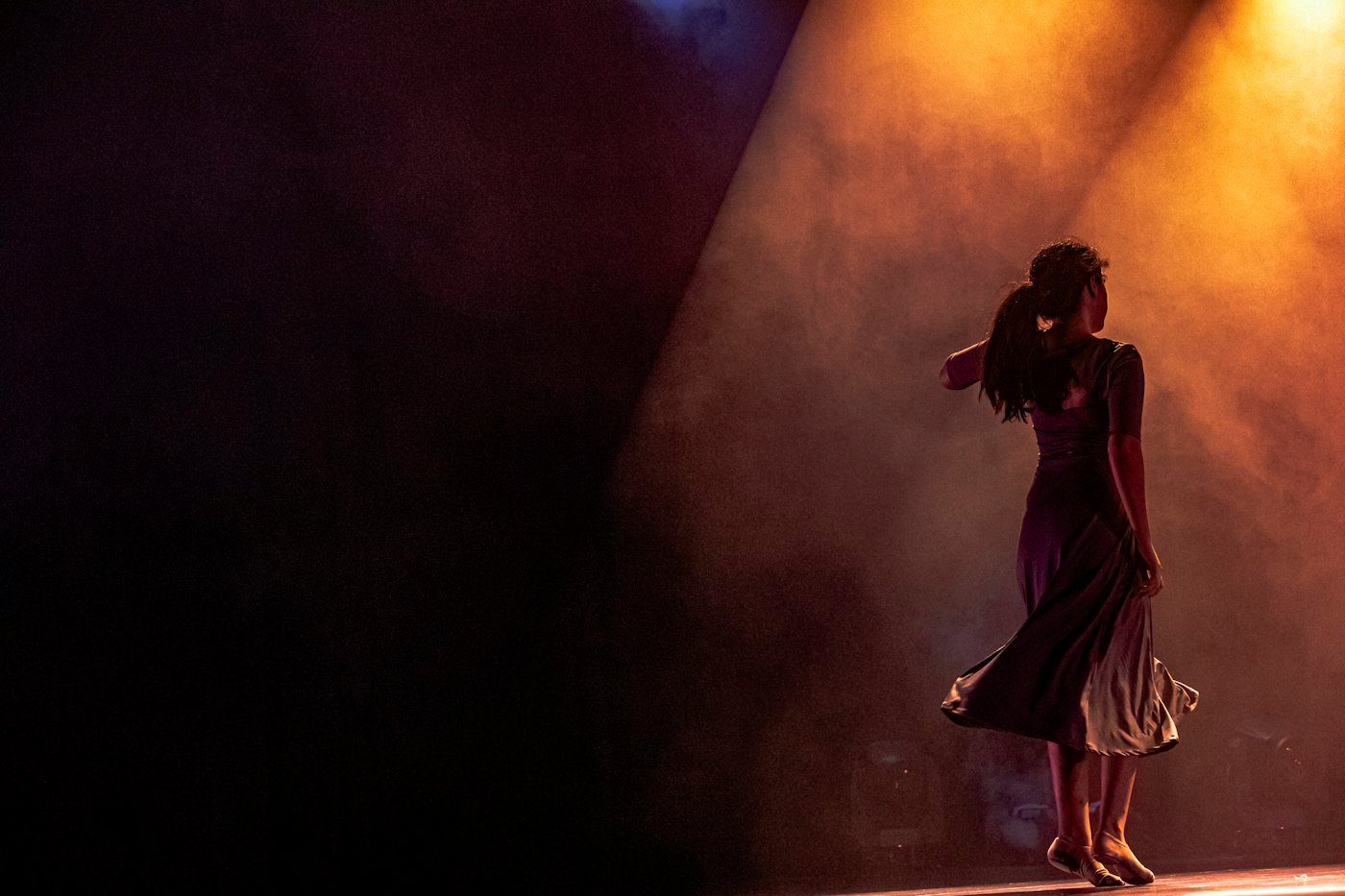 Danseuse seule dans un faisceau de lumière chaude
