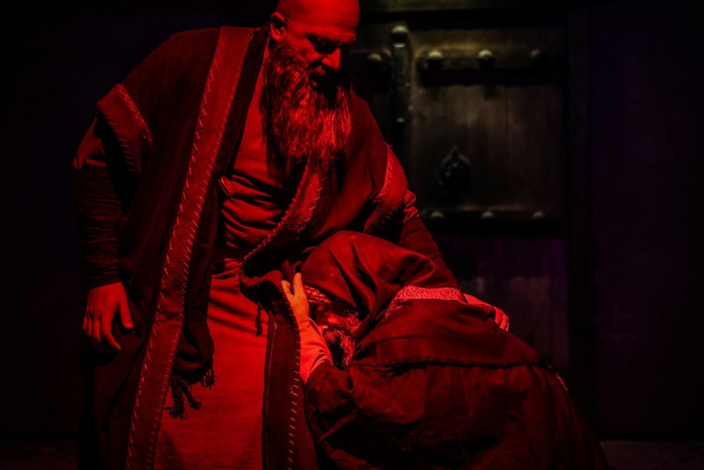 Interprète drapé de rouge dans un décor de théâtre